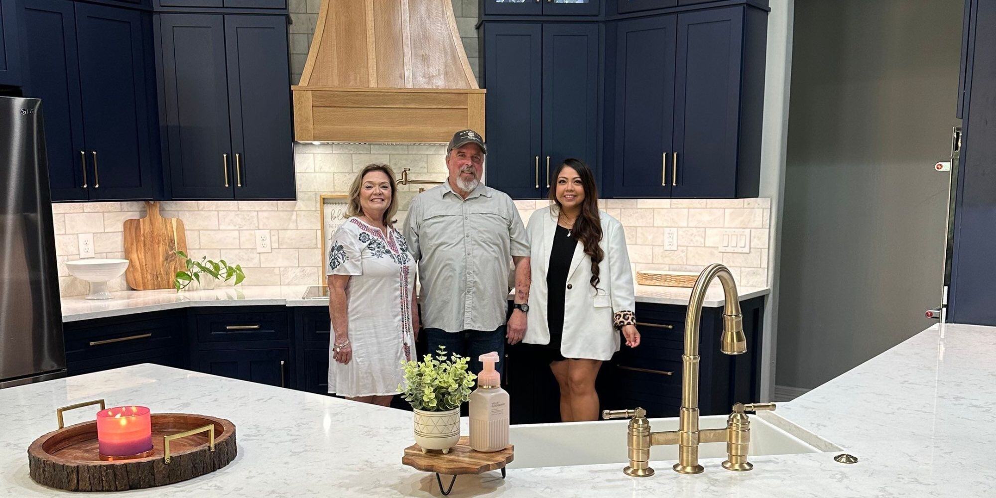 Family standing in front of their remodeled kitchen in spring branch tx with blue cabinets and white countertops and backsplash Family standing in front of their remodeled kitchen in spring branch tx with blue cabinets and white countertops and backsplash
