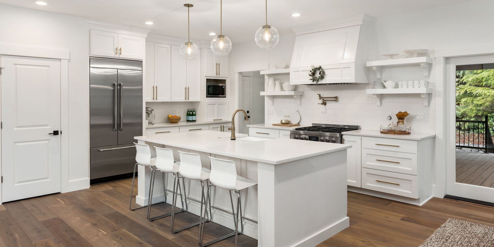 open layout kitchen with white cabinets, dark wood floors, and a large kitchen island with bar stool seating