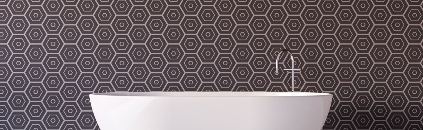 White standalone tub in front of wallpapered wall